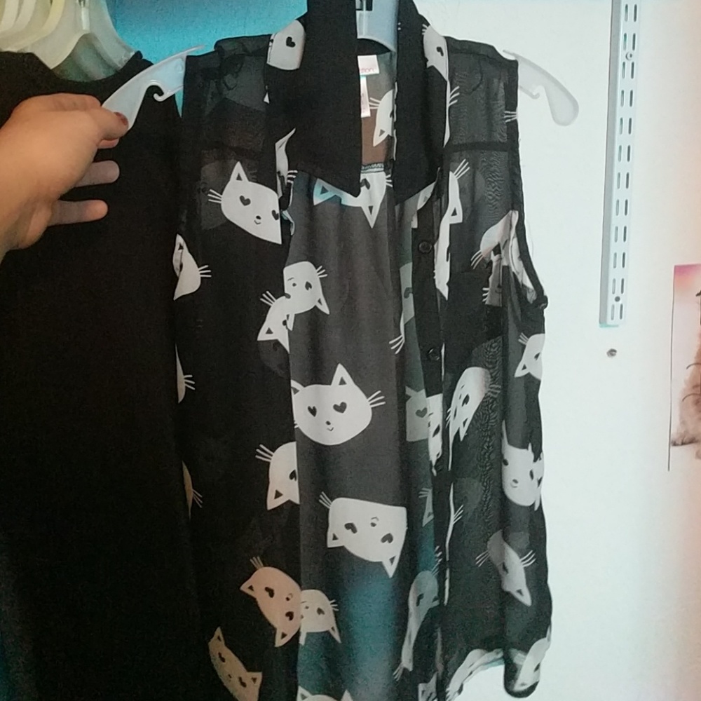 Black vest with white cats on it.
